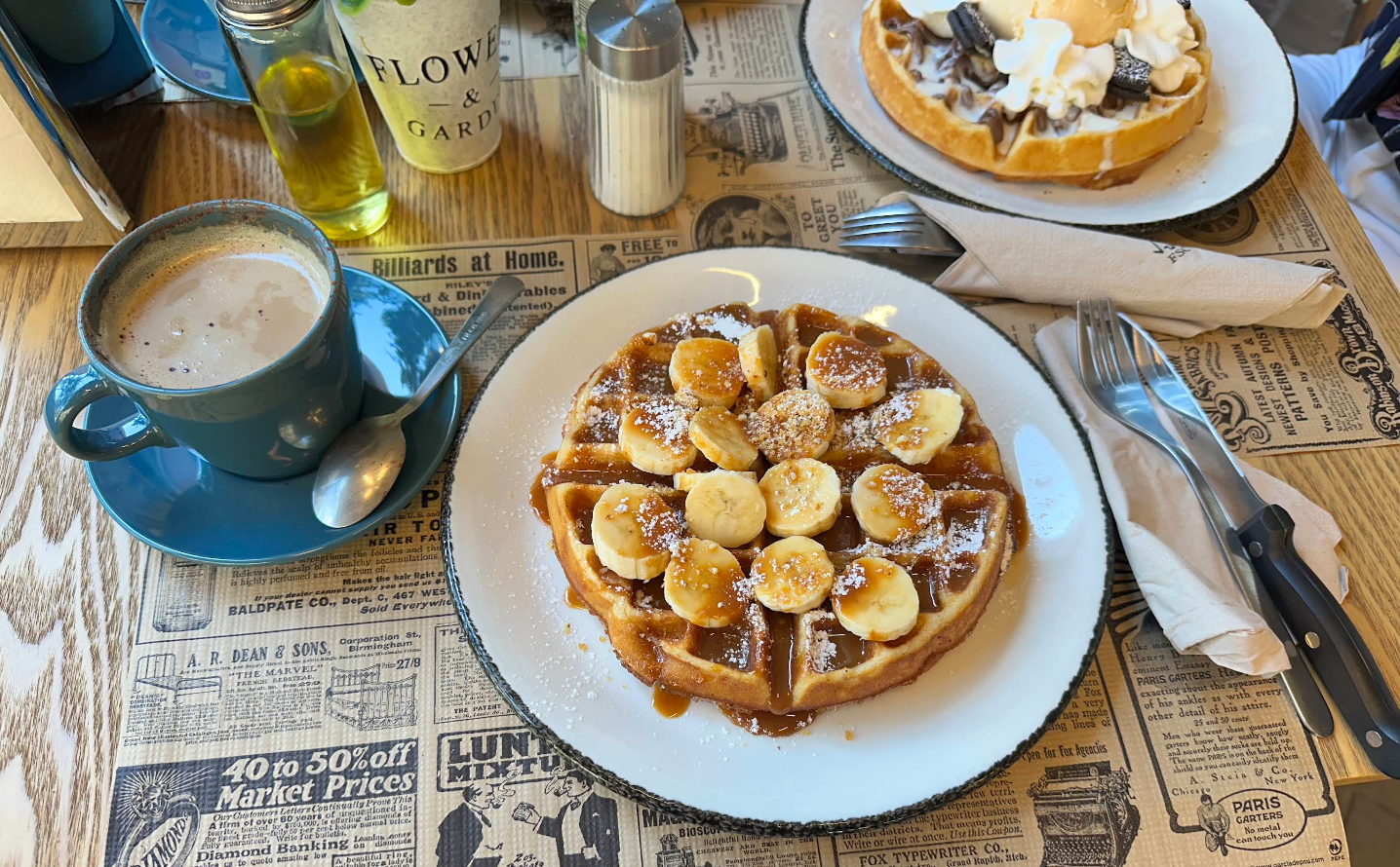 Gofre dulce con plátano, caramelo y azúcar glass acompañado de café con leche